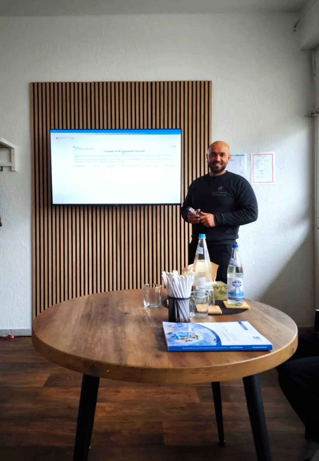 Trainer Osman Tawasin erklärt Deeskalationstechniken im Schulungsraum bei OPTSECURE