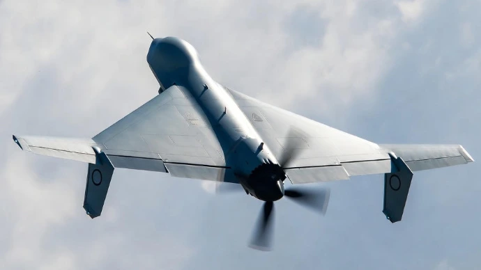 Nahaufnahme einer Kamikaze Drohne, die vor einem hellen Himmel schwebt.